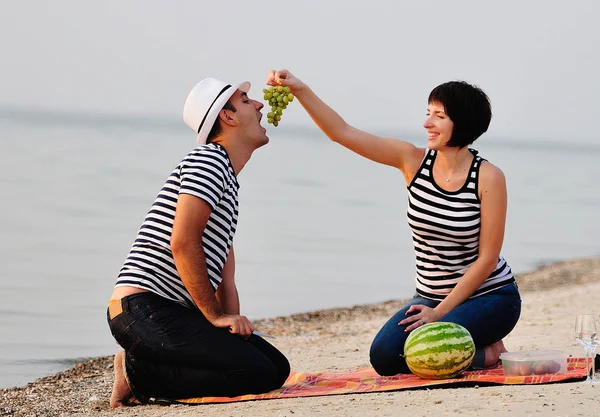 Casal sentado na praia com vinho — Fotografia de Stock