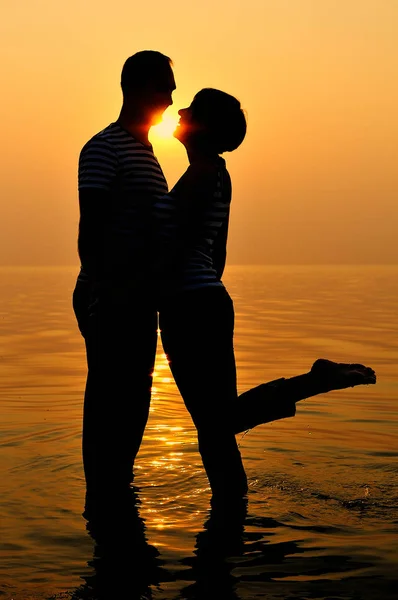 Casal feliz no mar ao pôr do sol — Fotografia de Stock