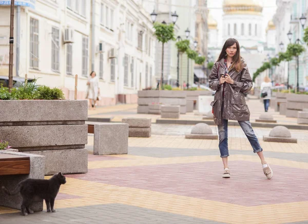Красива жінка, що йде з котом у місті — стокове фото