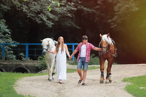 Jovem casal andando com cavalo — Fotografia de Stock