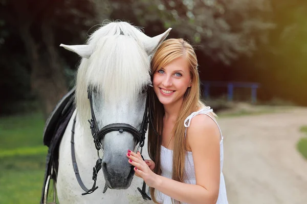 Beyaz atlı beyaz elbiseli genç kadın