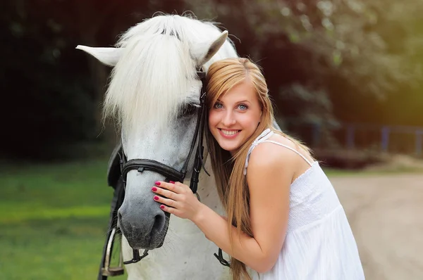 Beyaz atlı beyaz elbiseli genç kadın