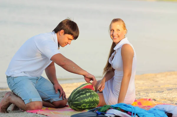 Pareja joven con una sandía en la orilla —  Fotos de Stock