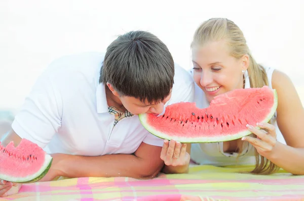 Jovem casal com uma melancia na costa — Fotografia de Stock
