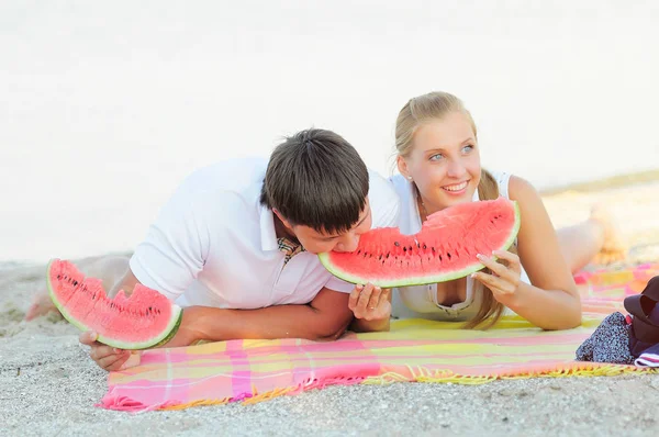 Jovem casal com uma melancia na costa — Fotografia de Stock