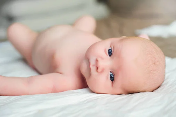 Infant liggande på sängen — Stockfoto