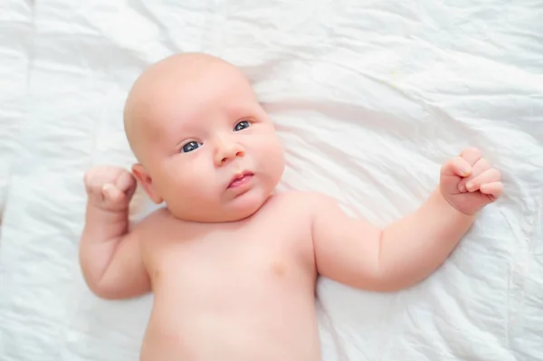 Infant liggande på sängen — Stockfoto