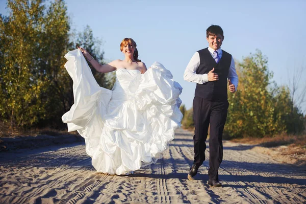 Gelukkige bruid en bruidegom lopen — Stockfoto