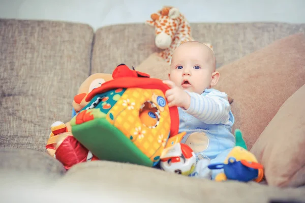 Голубоглазый ребенок на диване — стоковое фото