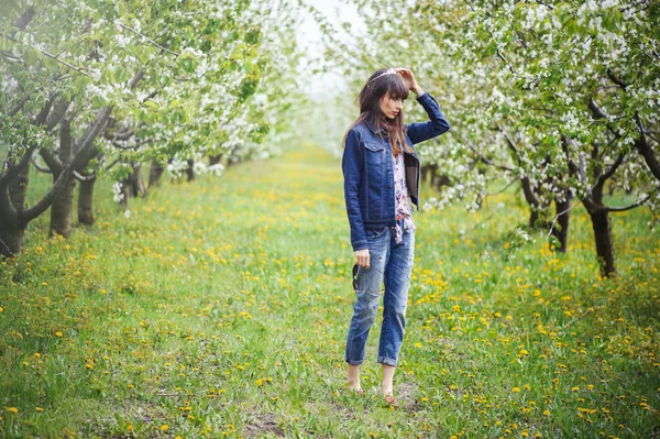 Frau in Jeans im Kirschgarten — Stockfoto