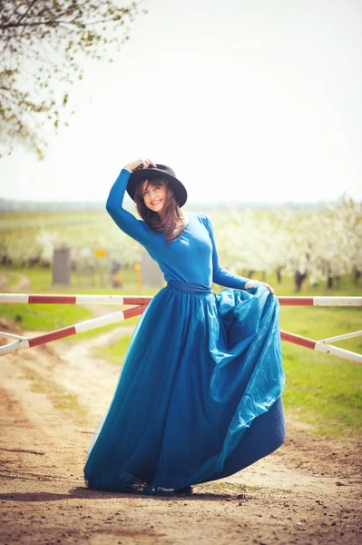 Красивая женщина в саду с воротами — стоковое фото
