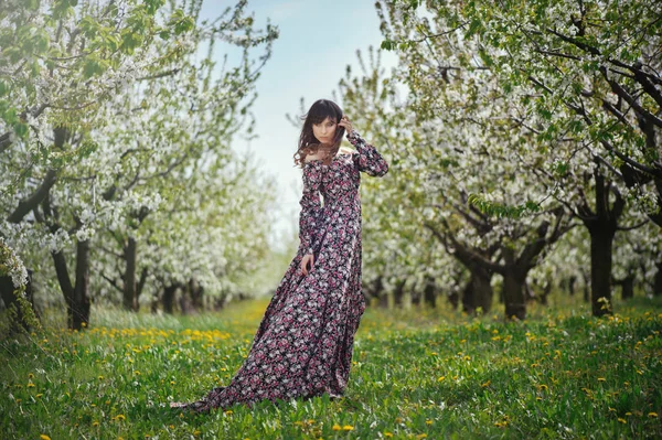 Krásná žena v šatech v zahradách — Stock fotografie
