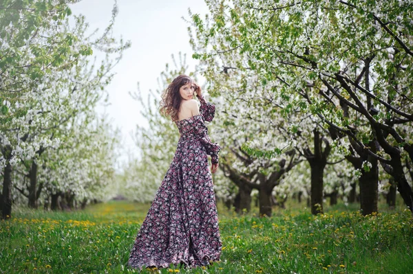 Красивая женщина в платье в садах — стоковое фото
