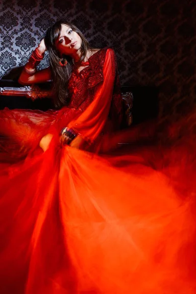 Kobieta w czerwieni macha sukienka we wnętrzu — Zdjęcie stockowe