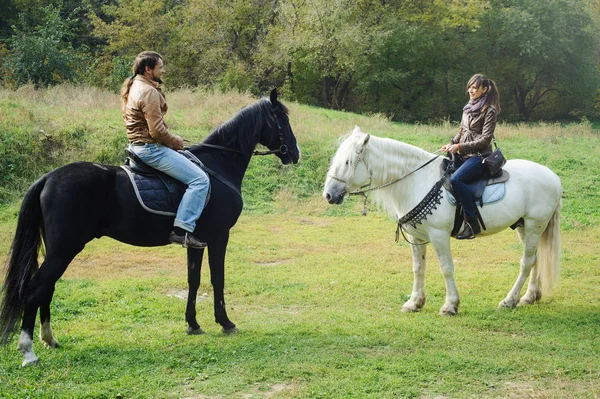 Homem e mulher em cavalos — Fotografia de Stock