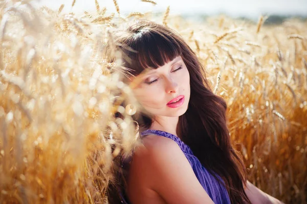 Retrato de una hermosa mujer en un campo de trigo — Foto de Stock