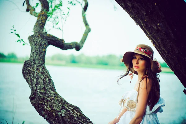 Беременная женщина сидит на дереве — стоковое фото