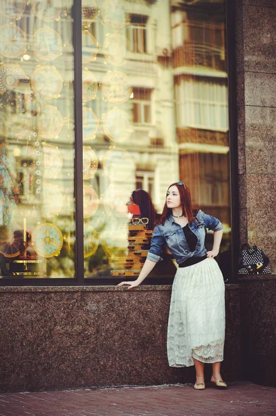 Красивая женщина у окна магазина — стоковое фото
