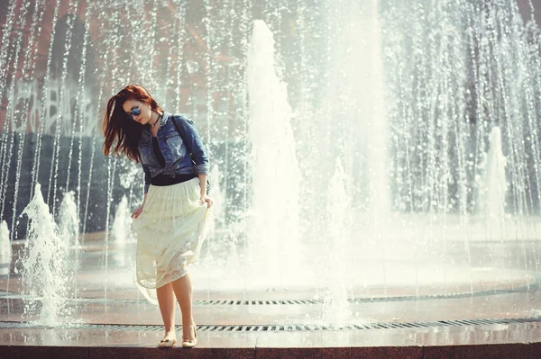 Mooie vrouw op de achtergrond van de fontein — Stockfoto