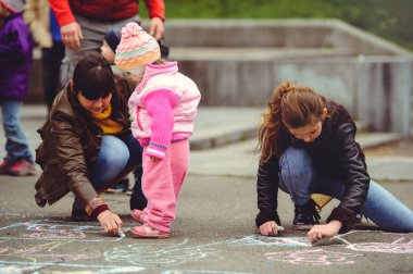 Ebeveynler ve çocuklar boya asfalt üzerinde
