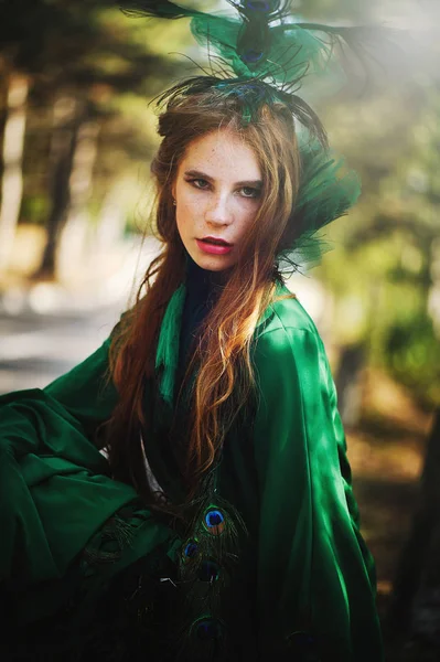 Красива дівчина з веснянками в зеленій сукні з прикрасою на голові — стокове фото