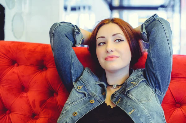 Una joven árabe de apariencia en un sofá rojo en un café espiando — Foto de Stock