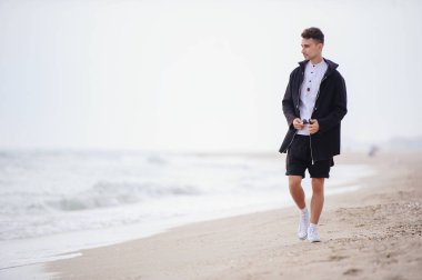 Serin genç moda adam sahilde,