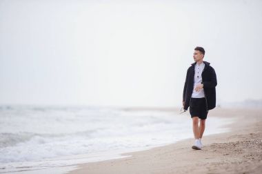 Plaj, sabah erken düşünmenin vakti ve postorit planları genç moda insan yürüyor