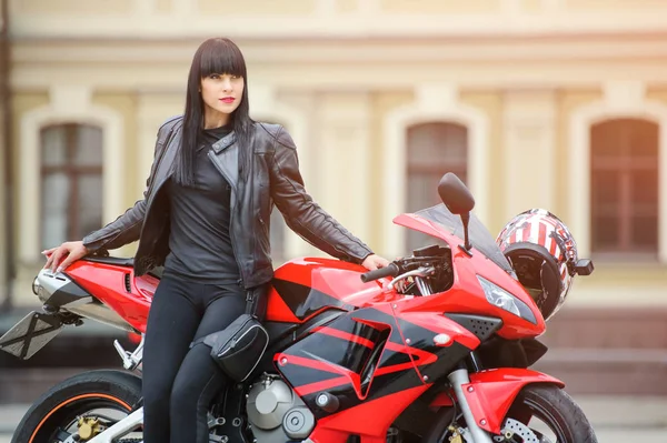 Liberdade e estilo. Retrato colorido de uma jovem com uma motocicleta vermelha . — Fotografia de Stock