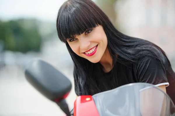 赤いバイクを持つ若い女性のカラフルな肖像画。女の子バイカーに見える鏡で、クローズ アップ — ストック写真