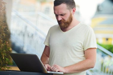 İş ve özgürlük. Şehir, serbest stil, modern iş bir dizüstü bilgisayarda arkasında bir sakallı.