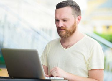 İş ve özgürlük. Şehir, serbest stil, modern iş bir dizüstü bilgisayarda arkasında bir sakallı.