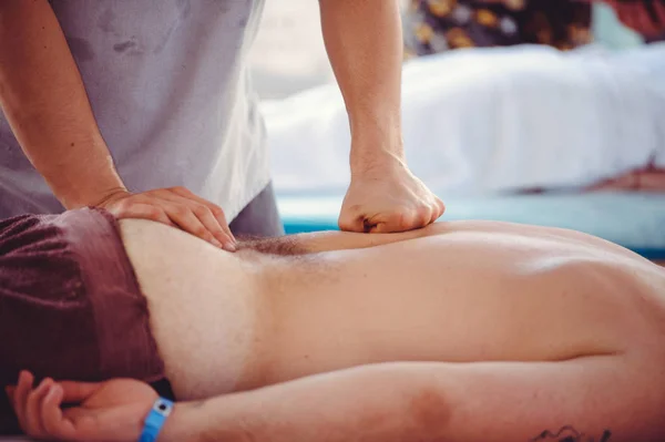 Las manos están haciendo masajes a un hombre. — Foto de Stock