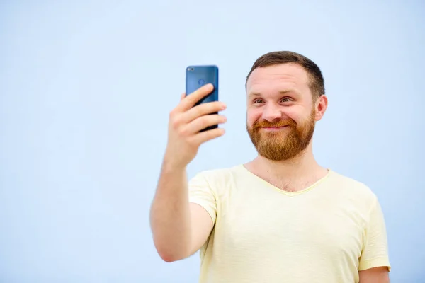 Člověk dělá obličeje v legrační a vtipné telefon dělá vážné tváře, reklamní společnost — Stock fotografie