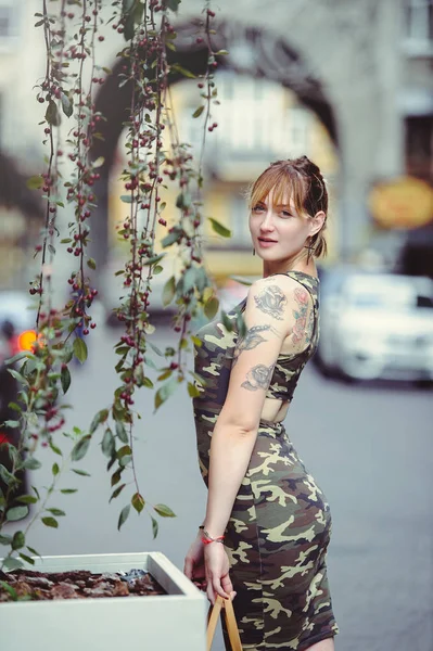 Piękna kobieta w sukni wojskowych w Miasto i tatuaż na ręce — Zdjęcie stockowe
