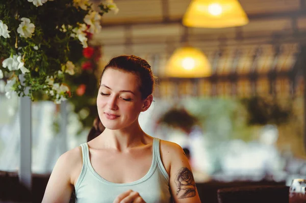 Güzel bir kadın açık bir kafede oturuyor