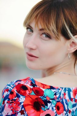 Bir elbise, yumuşak sıcak ışık, gün batımında şehirde güzel genç kadın ihale rahat ve tür