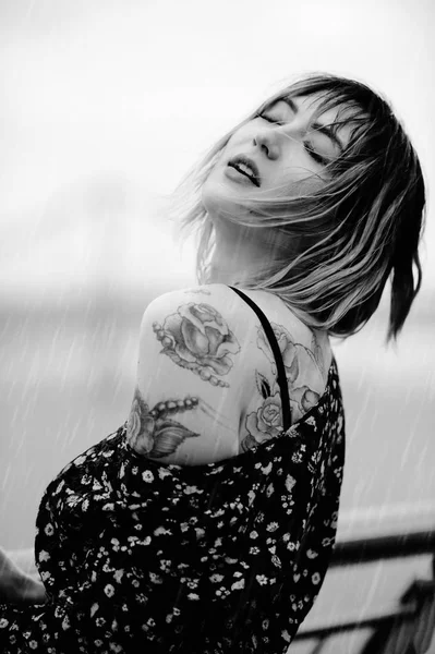 Beautiful young woman in the rain with a tattoo on her hands, sensual and gentle, wet hair. Black and white — Stock Photo, Image