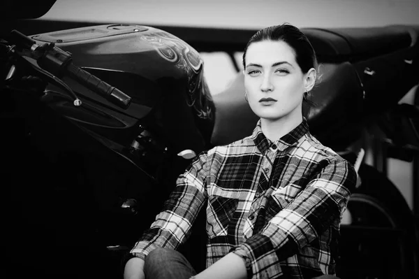 Serious woman in a shirt on a motorcycle background, smoothed hair, black and white — Stock Photo, Image