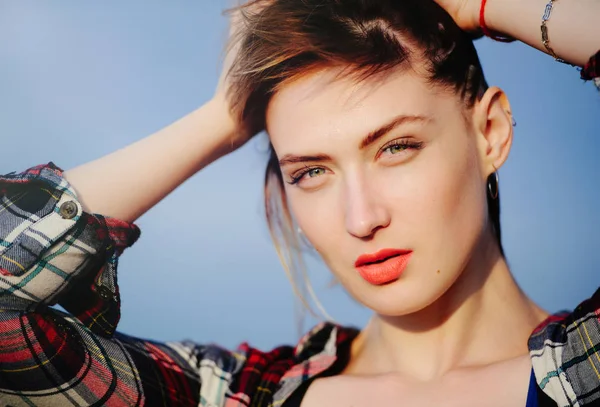 Retrato de una hermosa mujer en la calle después del atardecer, mirando a la distancia y alisándose el cabello — Foto de Stock