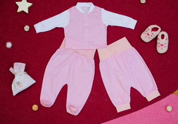 Kiraz bir arka plan üzerinde oyuncaklarla çocuk giyim