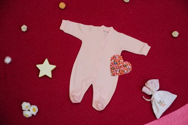 Kiraz bir arka plan üzerinde oyuncaklarla çocuk giyim