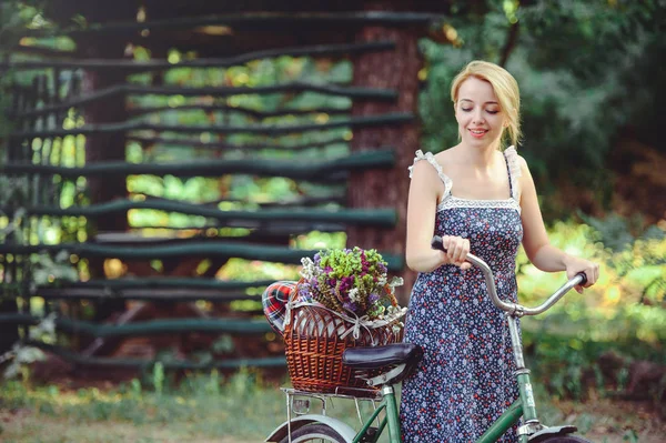 Woman with a bicycle in nature with an apple in her hand, a heal — Stock Photo, Image