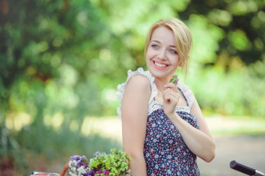 güzel kadın doğası üzerine bir bisiklet ile mutlu ve sağlıklı, ihale çiçek elinde, sağlıklı yaşam tarzı