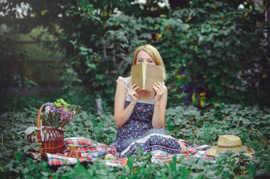 genç kadın doğada, duygulu ve nazik piknik bir kitap okuma