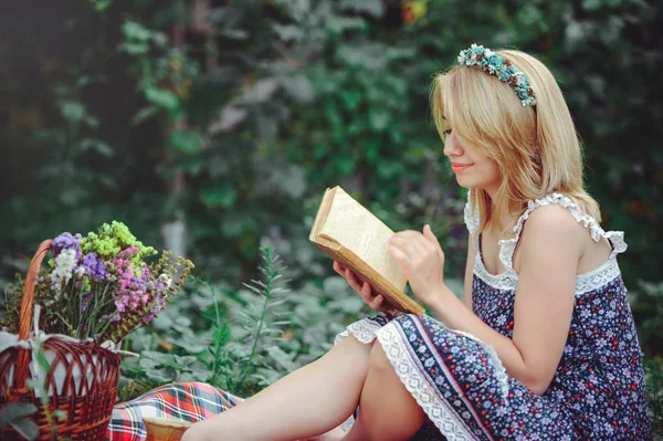 Νεαρή γυναίκα διαβάζοντας ένα βιβλίο στη φύση, πικνίκ καλόψυχος και απαλή — Φωτογραφία Αρχείου