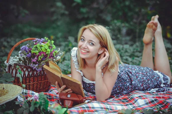 Νεαρή γυναίκα βρίσκεται διαβάζοντας ένα βιβλίο στη φύση, soulful και απαλή pi — Φωτογραφία Αρχείου