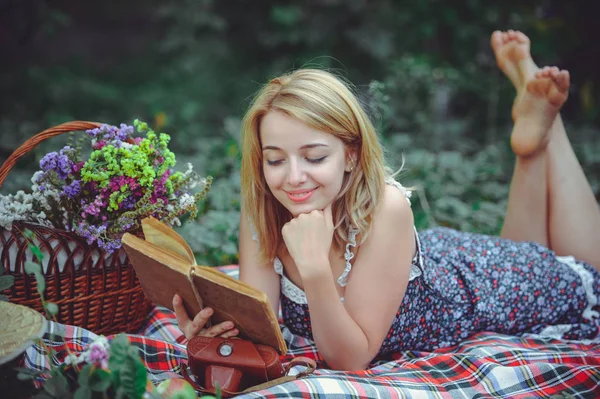 Νεαρή γυναίκα βρίσκεται διαβάζοντας ένα βιβλίο στη φύση, soulful και απαλή pi — Φωτογραφία Αρχείου