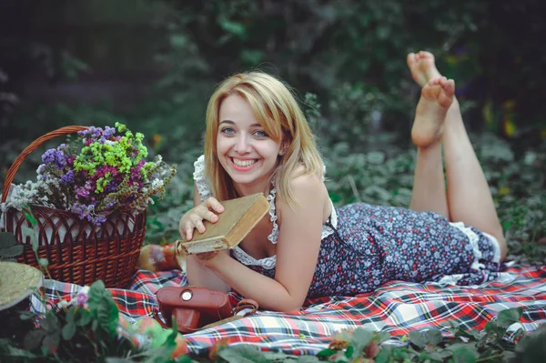 Junge Frau liegt beim Lesen eines Buches in der Natur, gefühlvolles und sanftes Picknick — Stockfoto