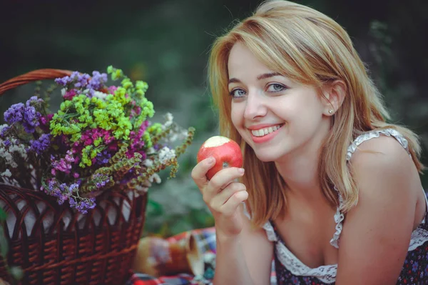年轻女人说谎与苹果在野餐会上，健康的生活方式，幸福 — 图库照片